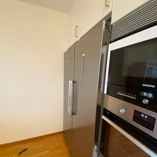 Kyl och frys på plats bredvid inbyggd ugn och mikrovågsugn