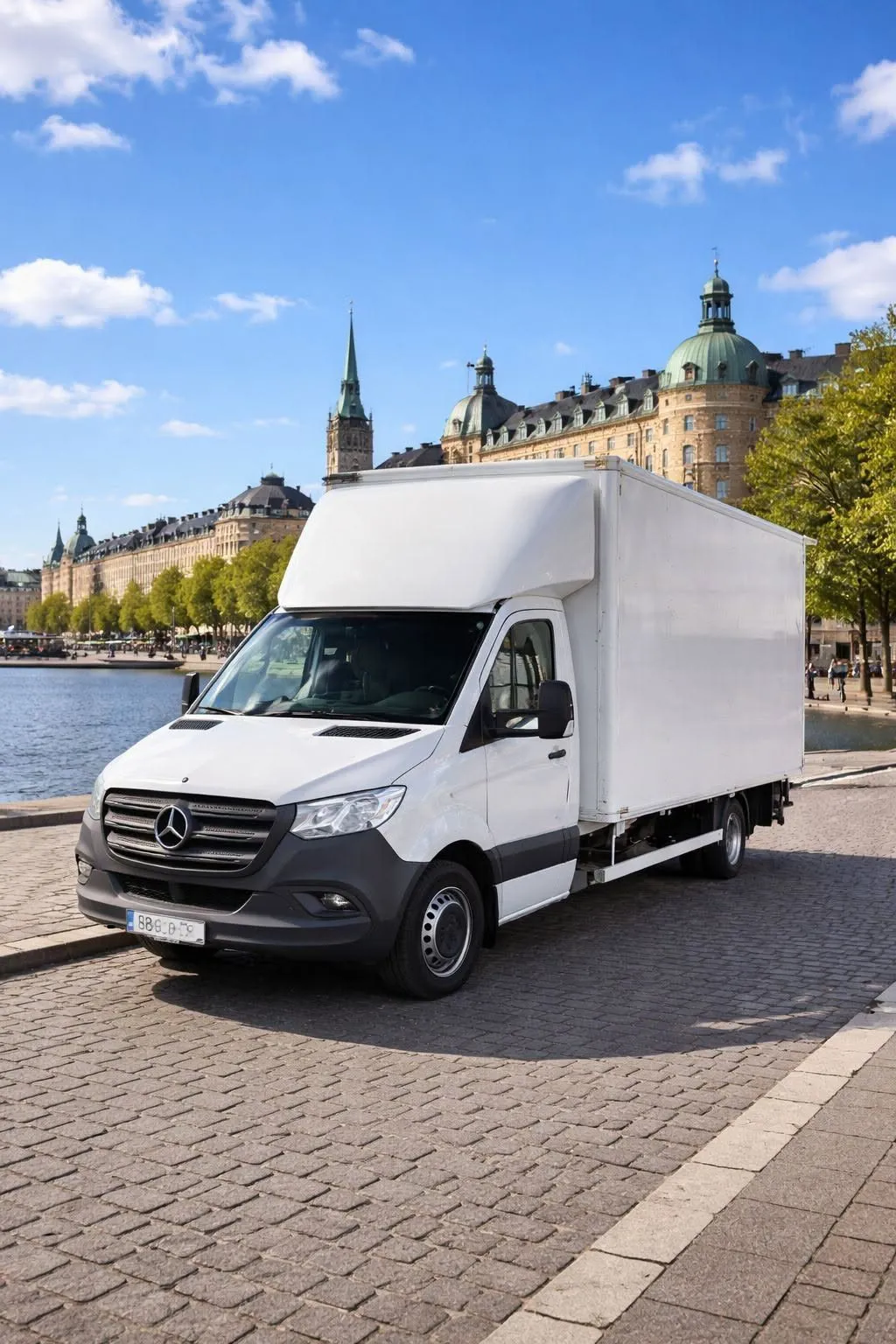 Vit lastbil med skåp parkerad vid vattnet i Stockholm en solig dag